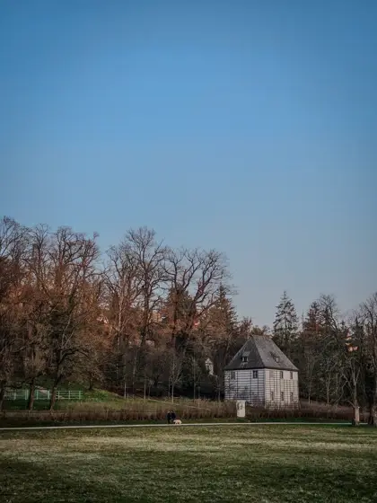Un pequeño pabellón recortado entre árboles de otoño.