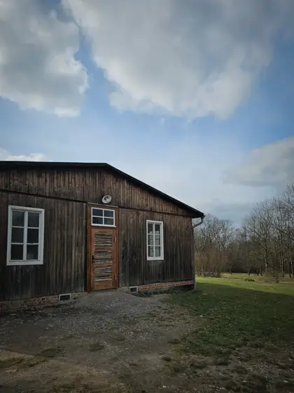 Una casa de madera sobre el borde del paisaje abierto.