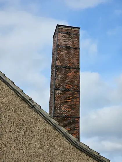 Una chimenea de ladrillo dibujando la vertical del conjunto.