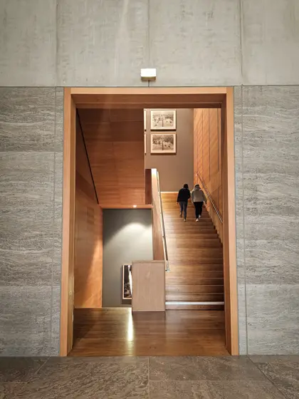 Escalera de madera enmarcada por un muro mineral.