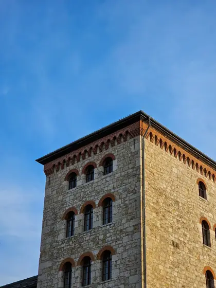 Mampostería irregular y pequeñas ventanas de una torre.