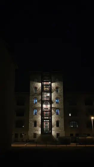 Una ventana iluminada en la oscuridad de la calle.
