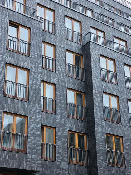 Marco de piedra y ventanas en una fachada urbana.