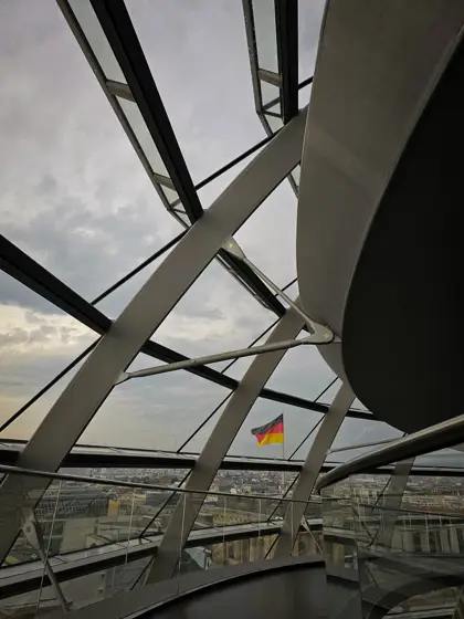 Cruce de piezas metálicas sobre la transparencia del cerramiento.