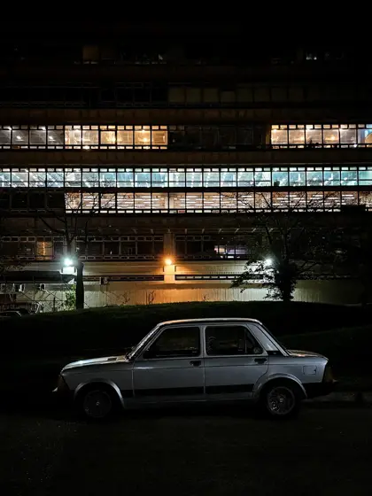 Franjas de luz sobre una fachada urbana nocturna.