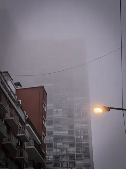 Una fachada alta que se disuelve entre la niebla.