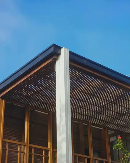 Pilares y cubierta de madera en un espacio de transición.