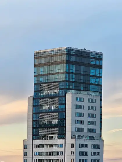 Torre de vidrio y bandas opacas dentro del tejido urbano.