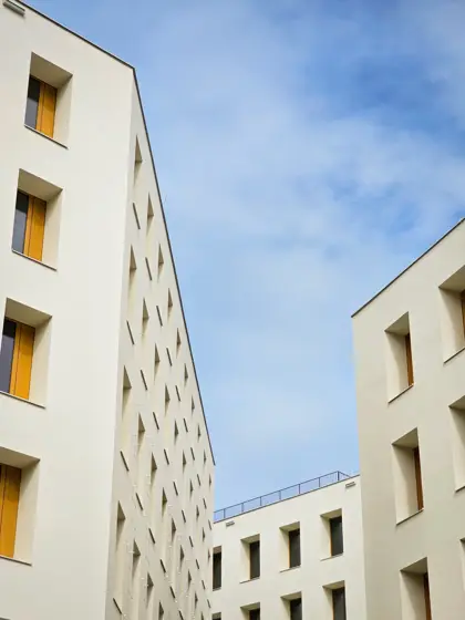 Ventanas profundas: espesor y sombras sobre el muro blanco.
