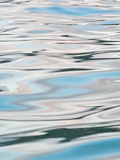 Ondulaciones y reflejos de color sobre la superficie del agua.