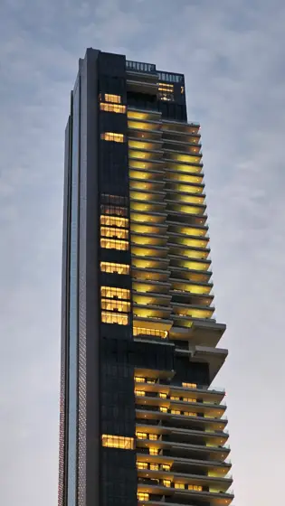 Franjas cálidas de luz sobre una torre nocturna.
