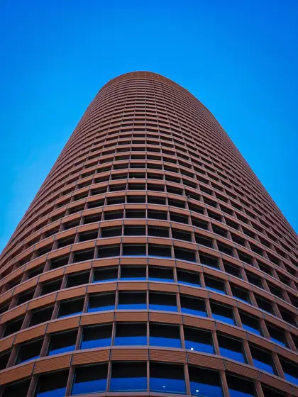 Torre de bandas horizontales y perfil curvo contra el cielo.