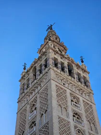 Campanario y ornamentación de piedra vistos desde abajo.