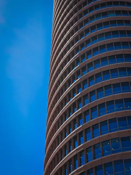 Ritmo de ventanas y curvas de una torre urbana.