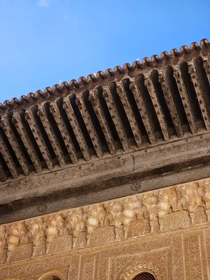 El alero de madera y la ornamentación del muro.