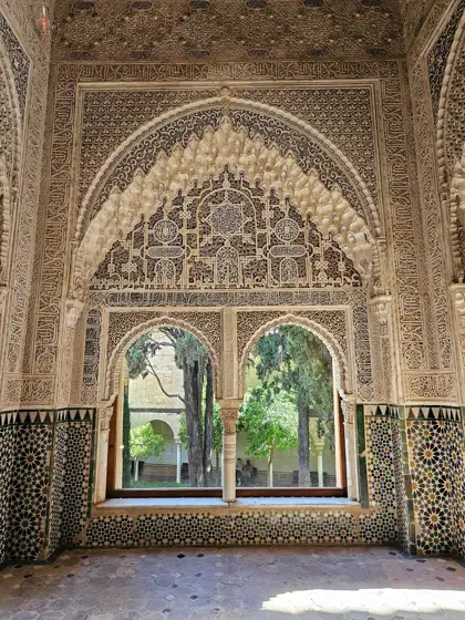 Un arco ornamentado enmarcando el jardín exterior.