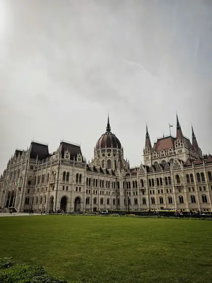 Un edificio histórico extendido frente a la explanada verde.
