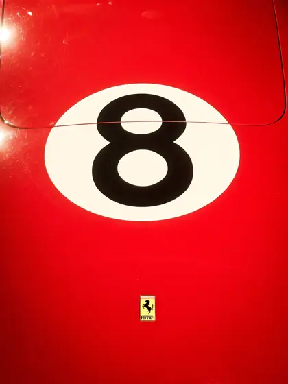Número y emblema sobre el rojo de un automóvil de competición.