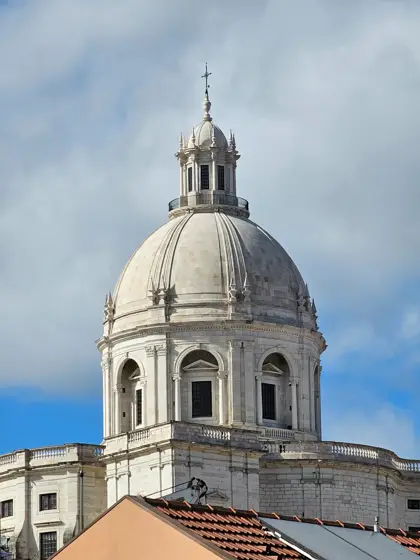Cúpula y tambor emergiendo sobre una fachada clara.