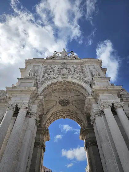 Arco de piedra y relieve ornamental contra el cielo.