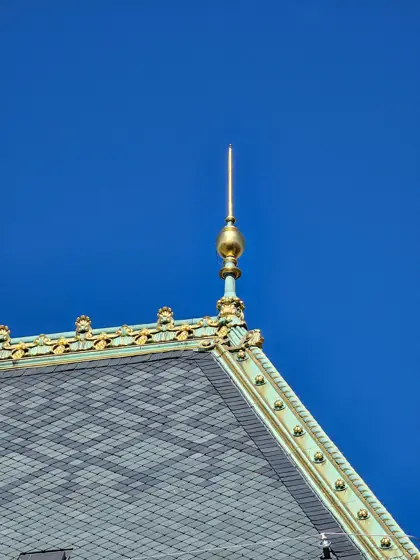 Tejas de pizarra y ornamento dorado en la cumbrera.