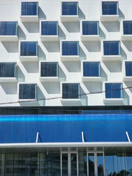 Ventanas profundas en una retícula de volúmenes blancos.