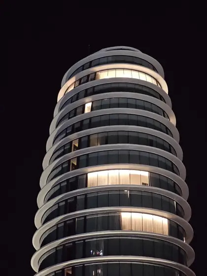 Franjas de luz y curvas de una torre durante la noche.