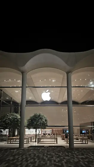 Apple Aventura: luz interior detrás del gran frente vidriado.